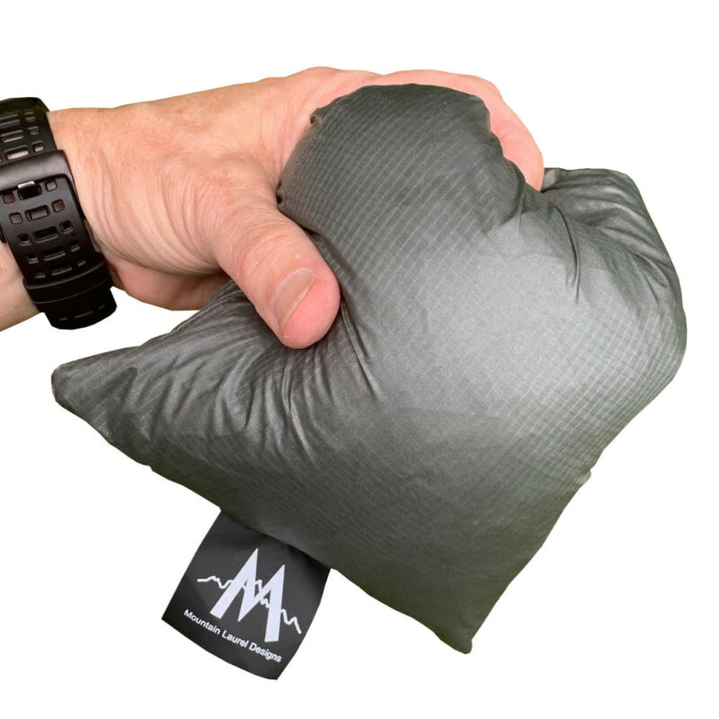 The MLD Pro Poncho in its Stuff Sack held in a man's hand.