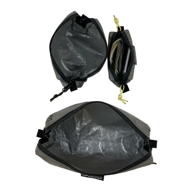 An open (unzipped) view of the ECOPAK ULTRA PACKING CUBES looking down. The medium and small are on the top; the large is on the bottom. The small one contains ID and a fat stack of folded bills.