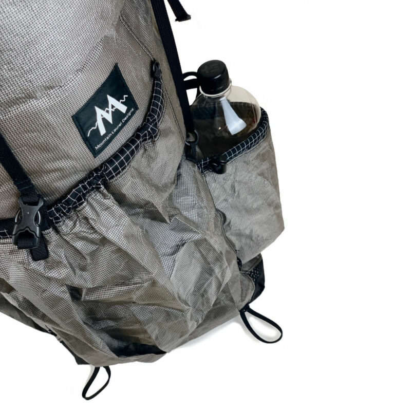 A detail image of the pocket and front pocket on the MLD EcoPak Exodus. therre is a water bottle in the pocket.