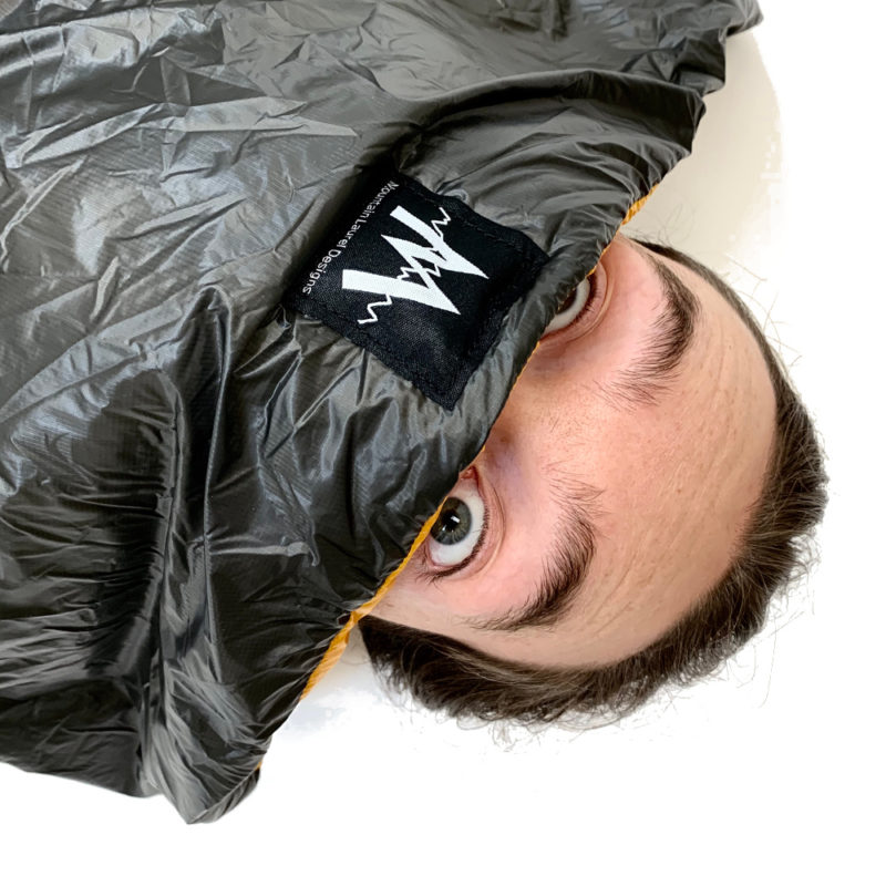 How You Look When You See a Bear in the Vision Quilt. A man's eyeballs peek out of his quilt.