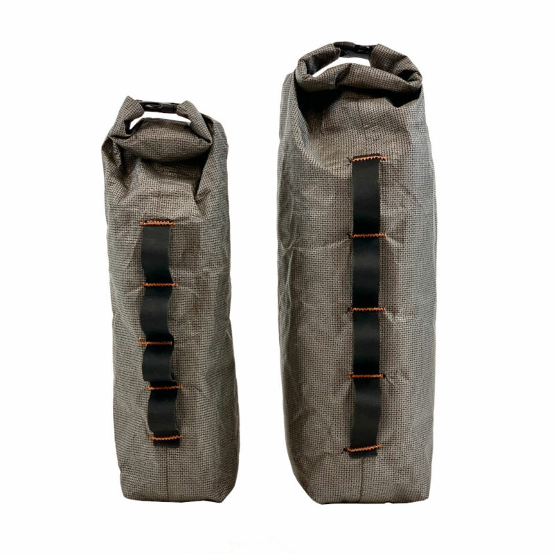 A side view of the Ultra Fork Dry Bags with the 1.6L on the left and the 2.5L on the right. Daisy chain is visible on side facing camera, and roll-top is visible on top.