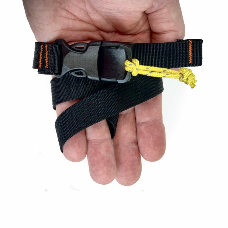 A man holdss a Bikepacking Strap in his hand. The buckle is facing up.
