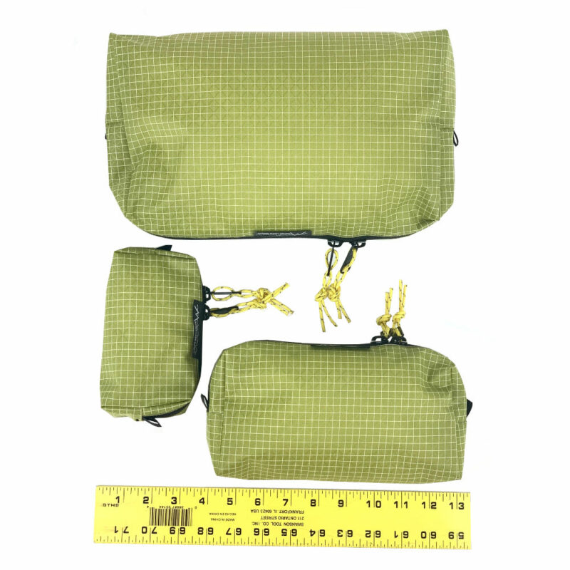 A size comparrison of the Wasabi Packing Cubes with the large at the top, and the small and medium on the bottom. A ruler shows the large is approx. 13" long, the medium is approx. 9" long, and the small is approx. 3" tall.