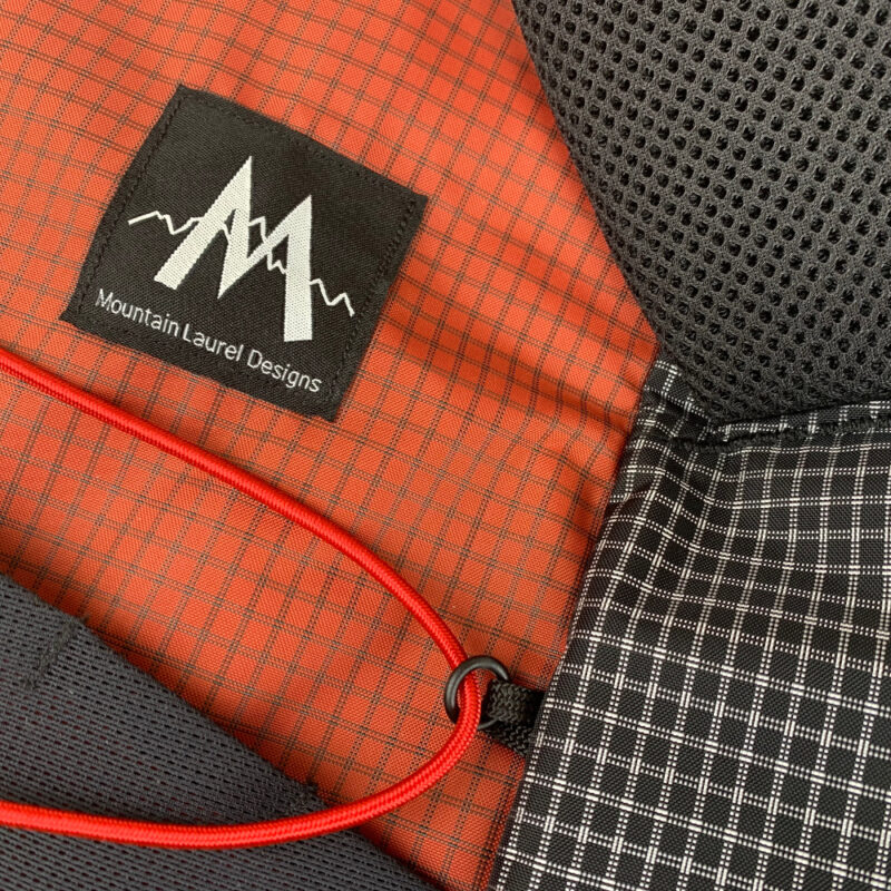 Pack details on the MLD Hell Pack showing the UltraGrid fabrics, back foam, and front bungee cord.