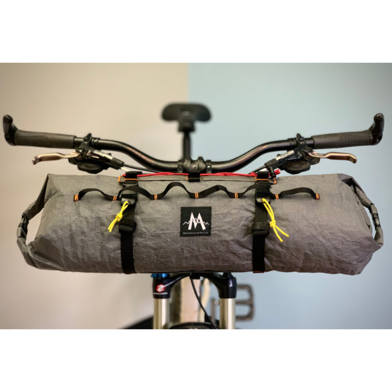 A front view of a Border Handlebar Harness System mounted on a bike holding an Ultra X Double End Handlebar Dry Bags